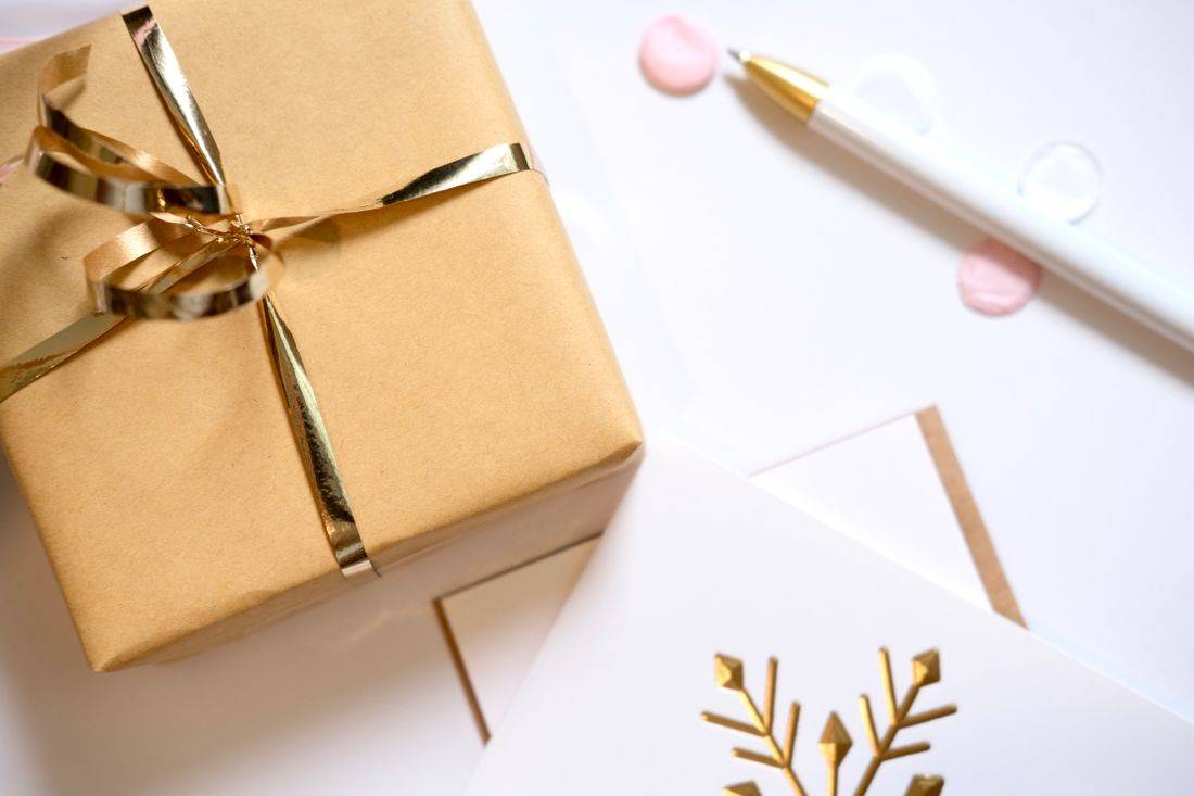 Kotak hadiah dengan pita emas untuk bonus member baru